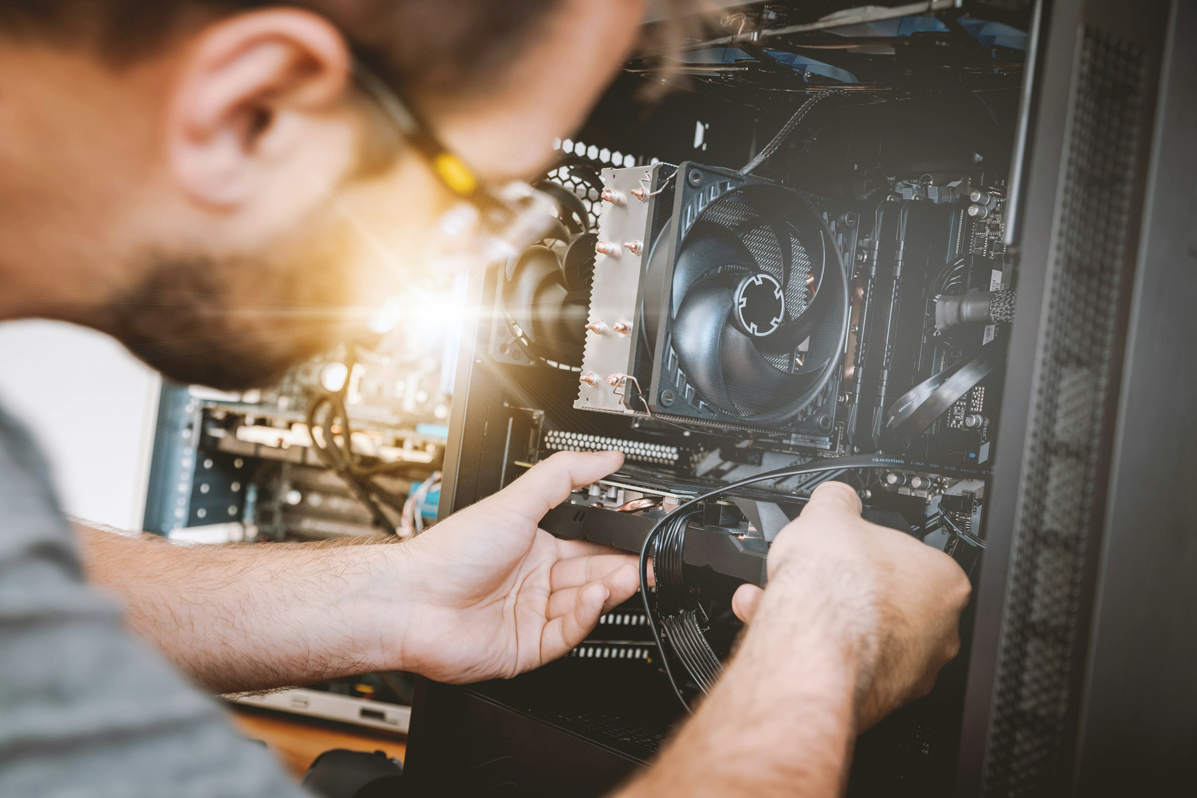 A technician installing a card in a desktop computer
